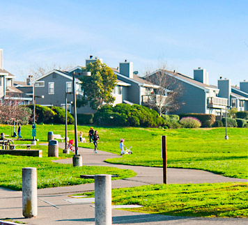 Greenbrae California Piper Park with green lush lawn, kids playing and condo’s in the background.
