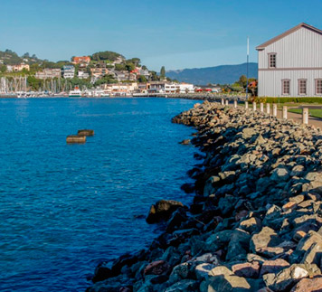 Rock wall in harbor next to Tiburon Ferry & Railroad Museum, Corinthian Yacht Club and Belvedere Island in background.